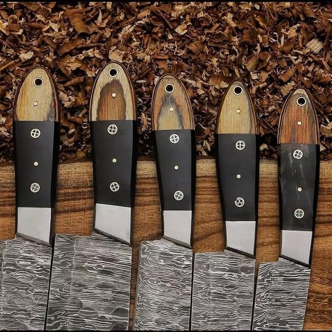 Close up of pakka wood handle tips on 5 Damascus knives