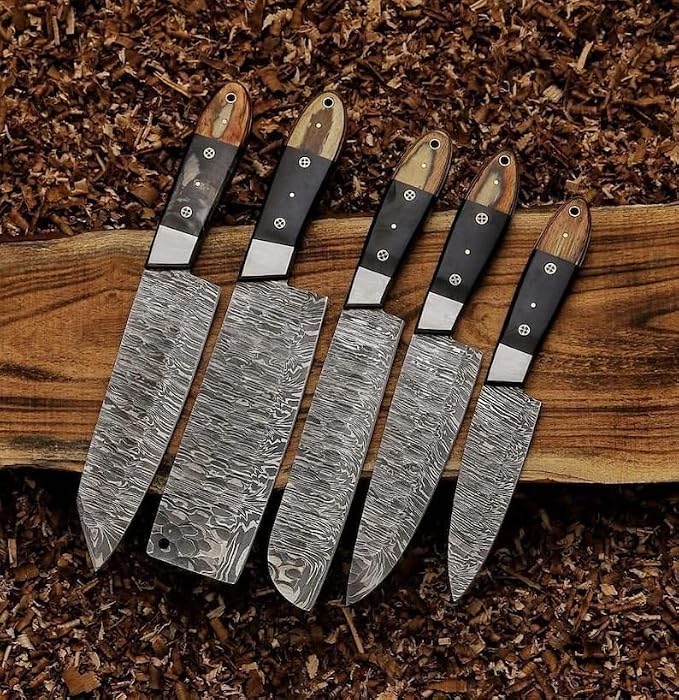 5 Damascus knives with pakka wood handles fanned on wood shavings
