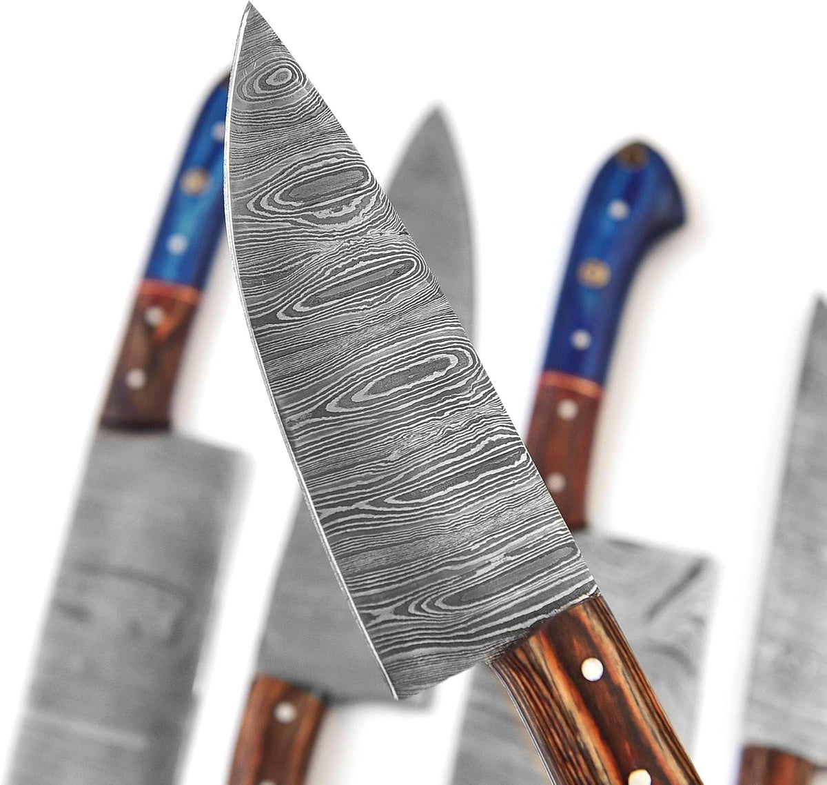 Damascus chef knife blade closeup showing the flowing layered pattern and fine tip