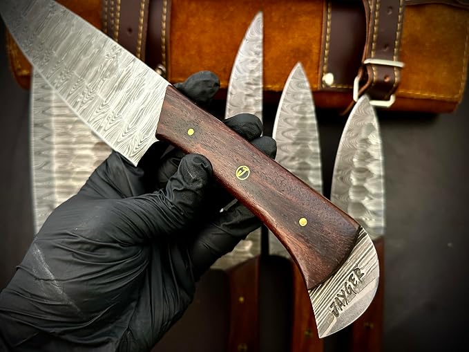 Hand holding a Damascus steel knife with a wood handle close up
