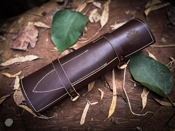 Brown leather knife roll rolled shut with a strap and cream stitching