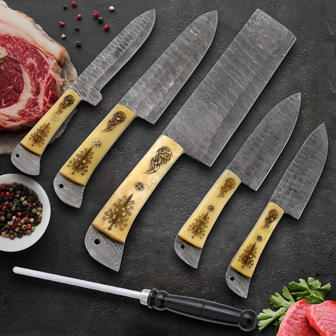 Damascus knife set with engraved bone handles beside ribeye steak and peppercorns