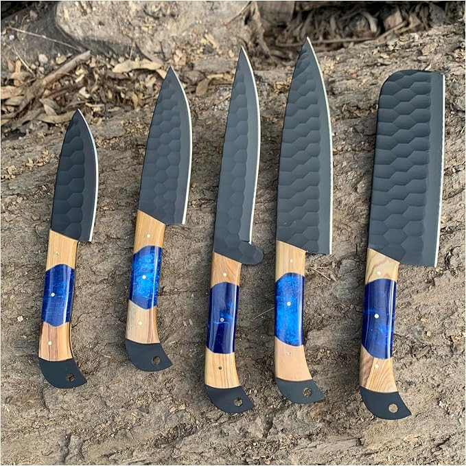 Five black finish steel knives with wood and blue resin handles arranged on bark