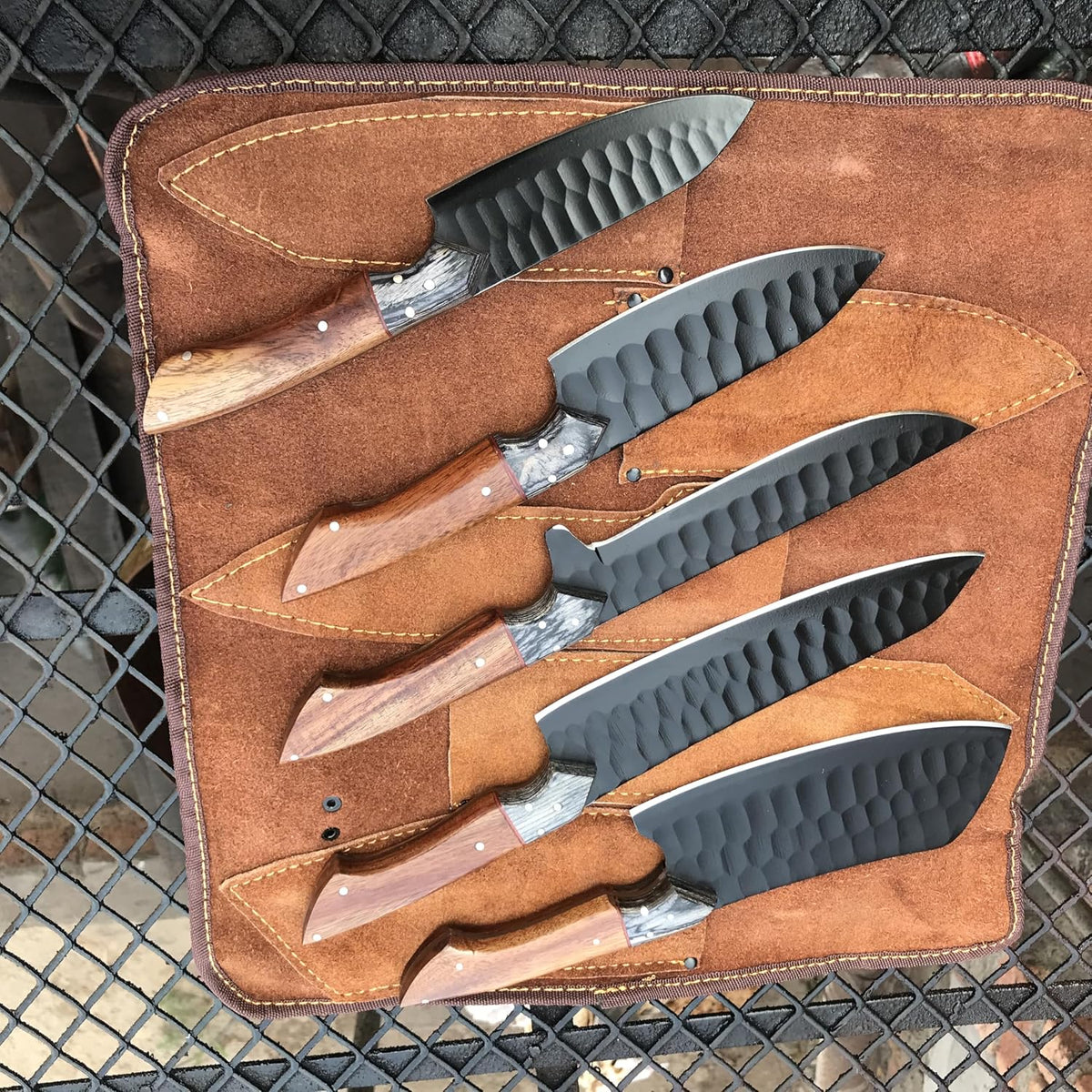 Black hammered cleaver, chef and santoku knives with rosewood handles in a roll