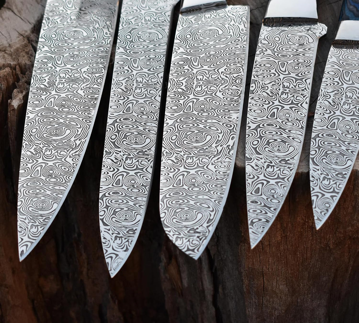 Etched swirl pattern on five stainless kitchen knife blades shown up close