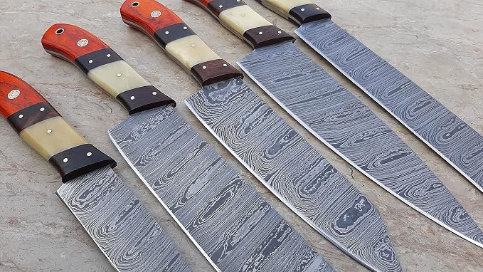 Close up of Damascus steel blades and pakka wood bone handle sections with dark spacers
