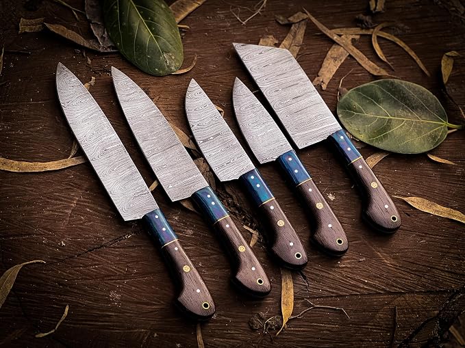 Damascus steel knife set with dark wood handles and teal spacers fanned outdoors