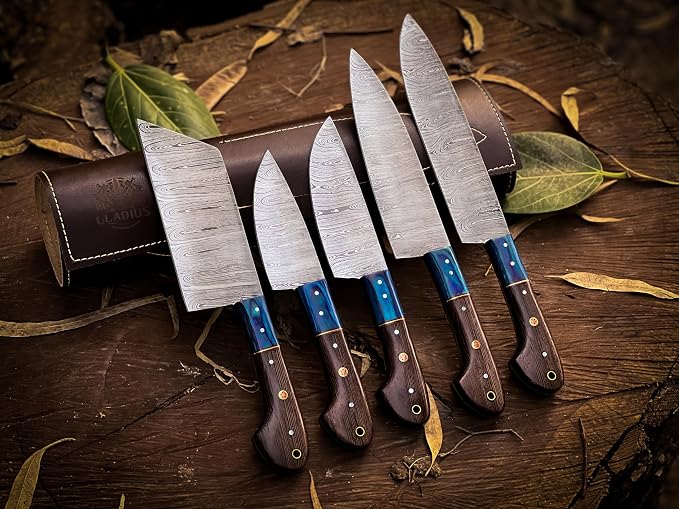 Five Damascus kitchen knives fanned in front of a rolled leather knife case