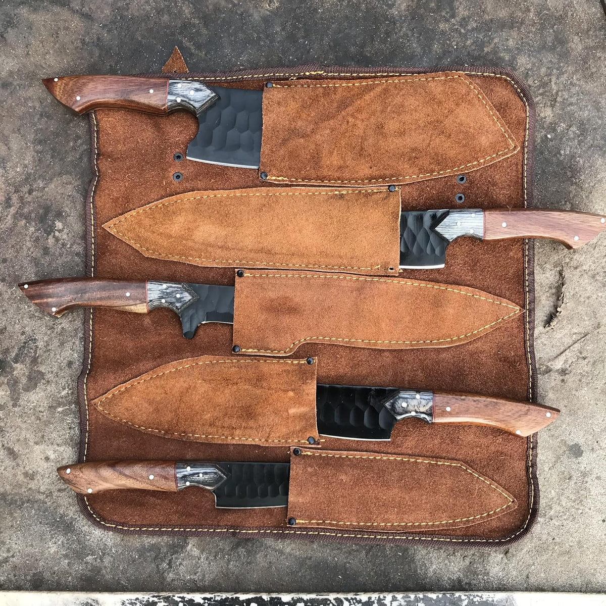 Black kitchen knife set of five in a tan leather roll with fitted sheaths