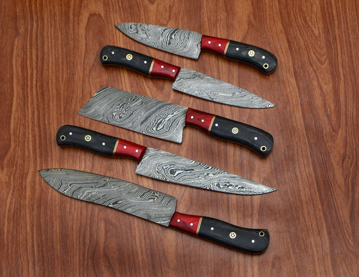 Black pakka wood handle knives with red bolster fanned on wood table