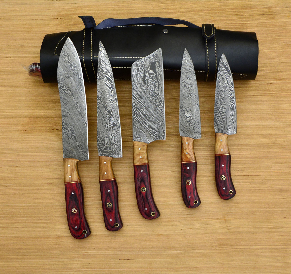 Damascus chef knife set fanned out beside black leather roll case