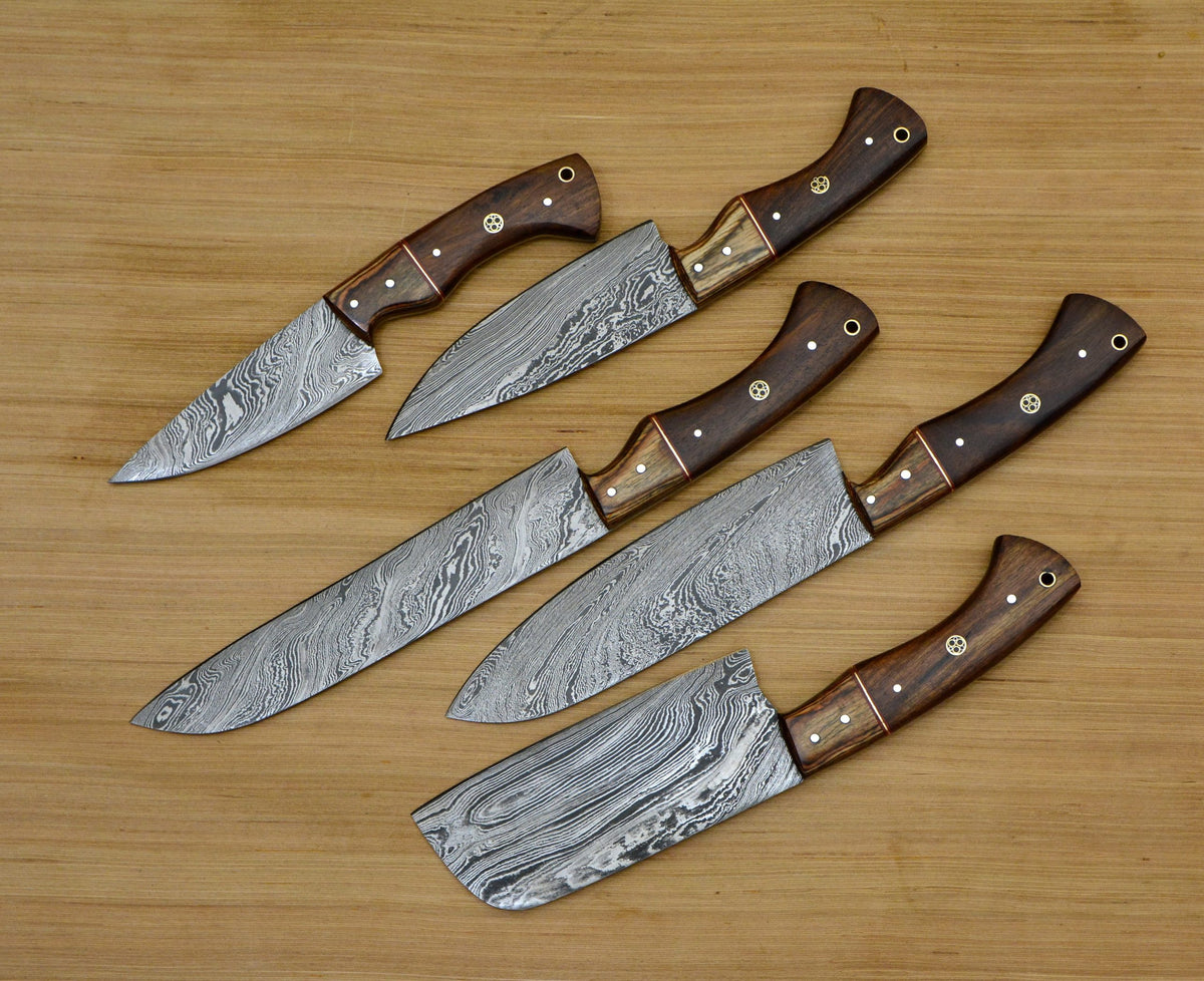 Five Damascus kitchen knives with two tone rosewood handles on a wood table