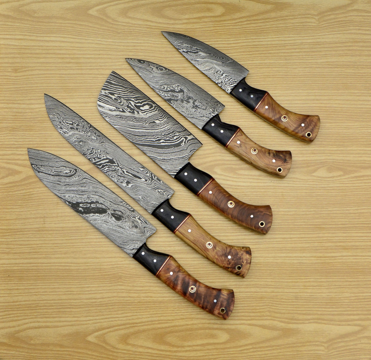 Damascus knife set of five fanned out showing olive wood and black bolsters