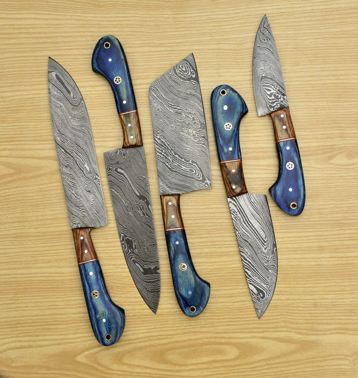 5 piece Damascus steel chef knife set fanned out showing tan bolster detail