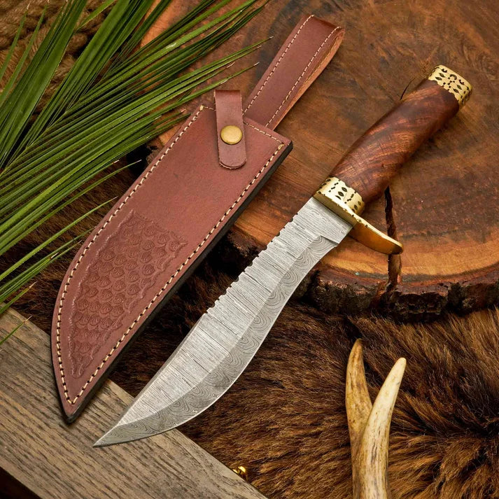 Damascus steel Bowie knife with rosewood handle beside leather sheath