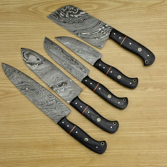 Five Damascus kitchen knives with black handles fanned across light wood