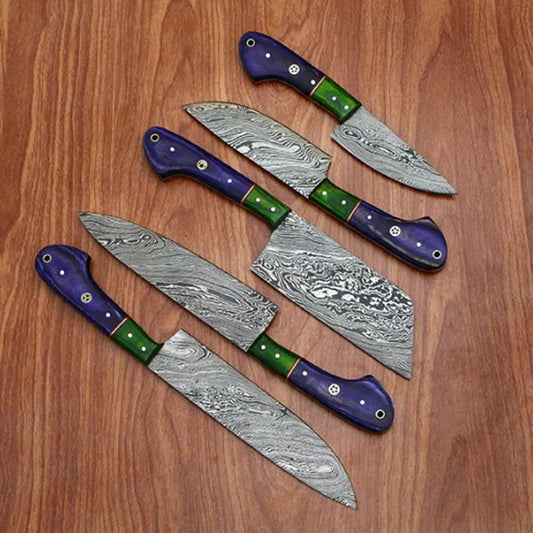 Five piece Damascus chef knife set with mosaic pin handles displayed on a wooden surface