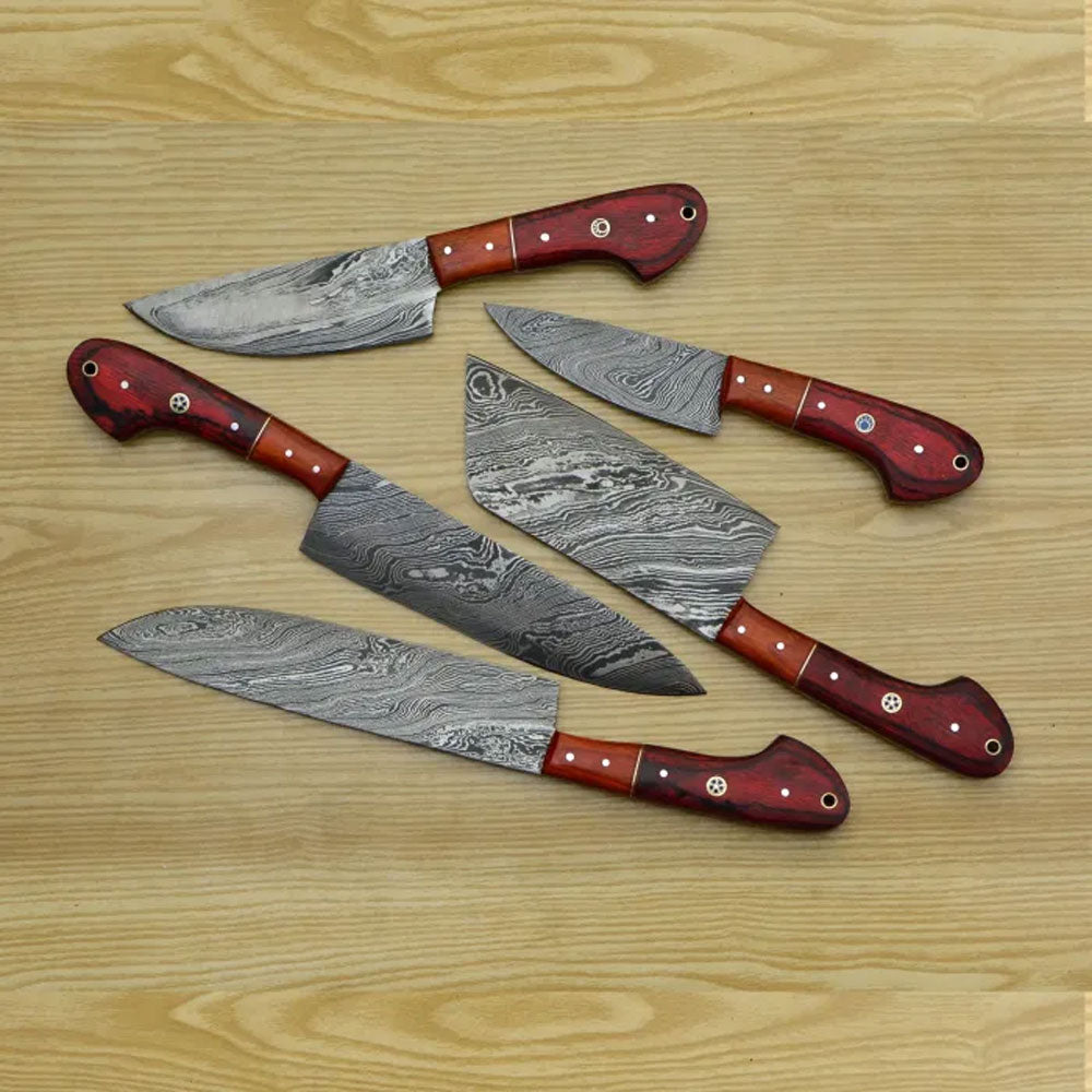lat lay arrangement of 5 pieces Damascus steel cooking knives with red wooden grips on a wooden texture