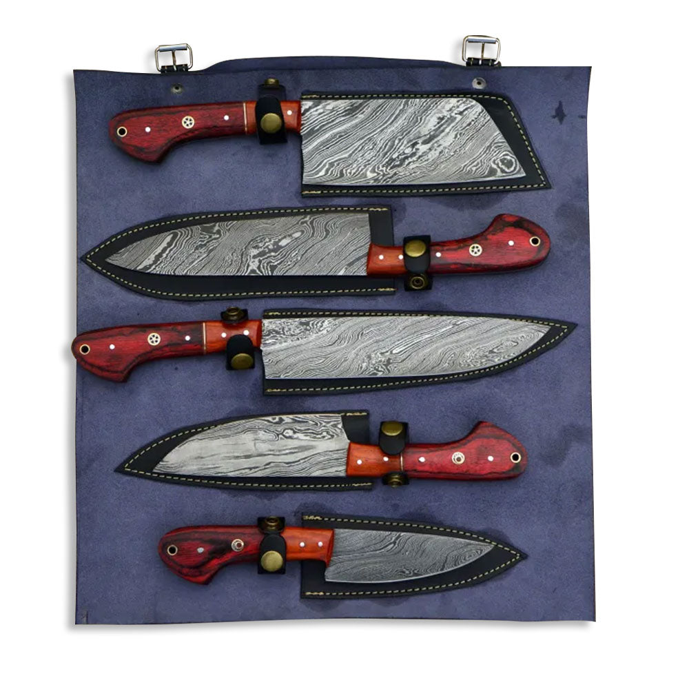 Damascus steel kitchen knife set with red wood handles displayed inside individual sheaths on a leather roll