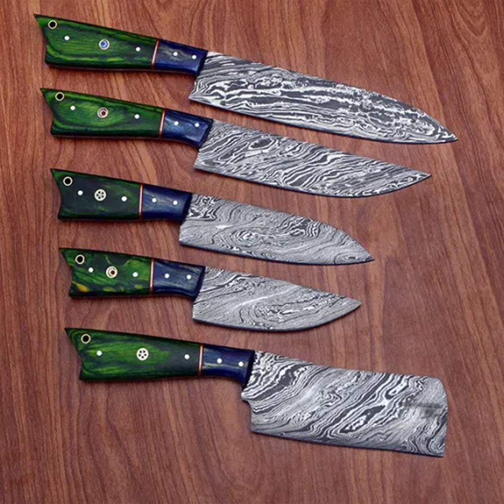 5 piece Damascus steel kitchen knife set with green pakka wood handles on a wooden surface