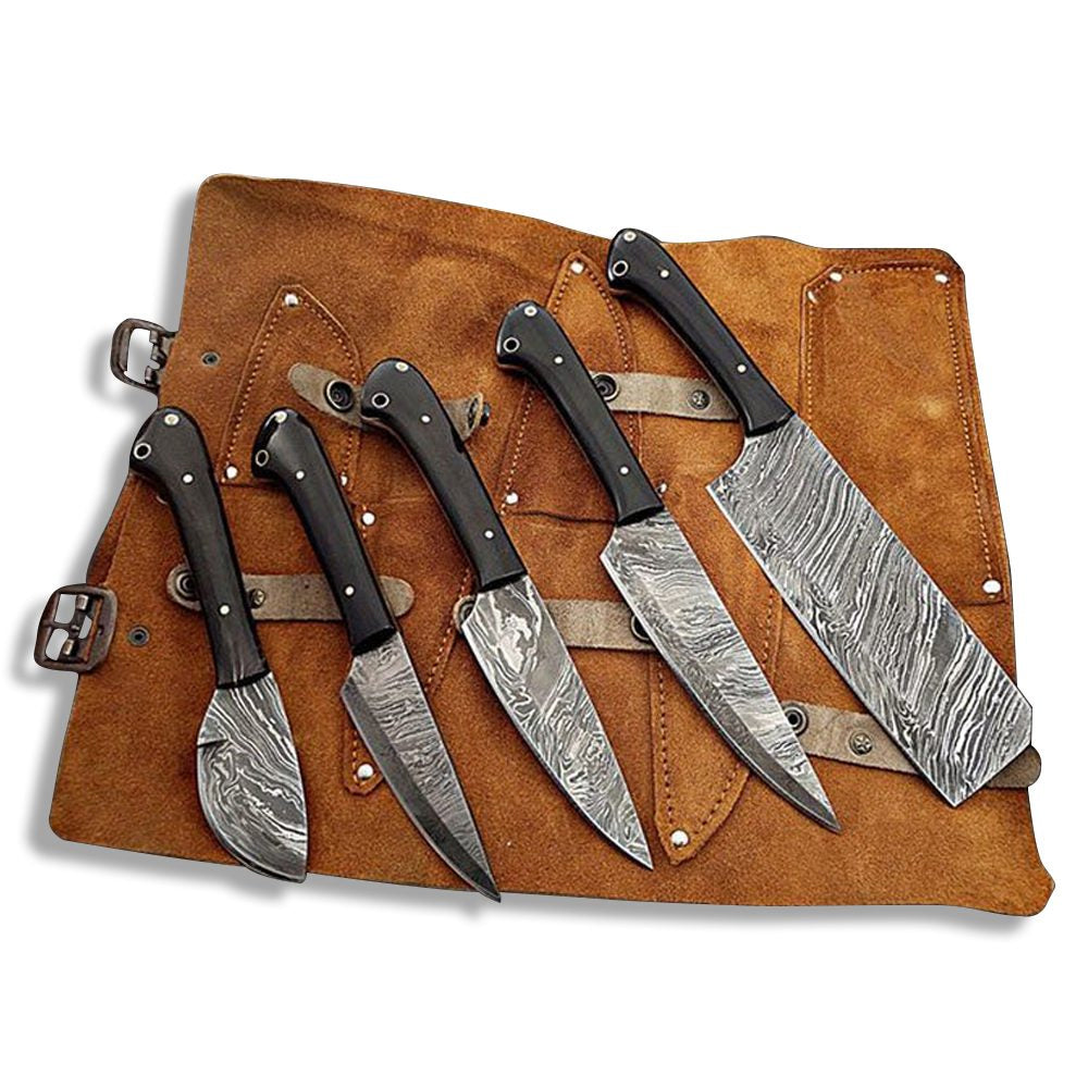 Custom Damascus steel culinary knife set with wood handles placed neatly on a leather storage roll