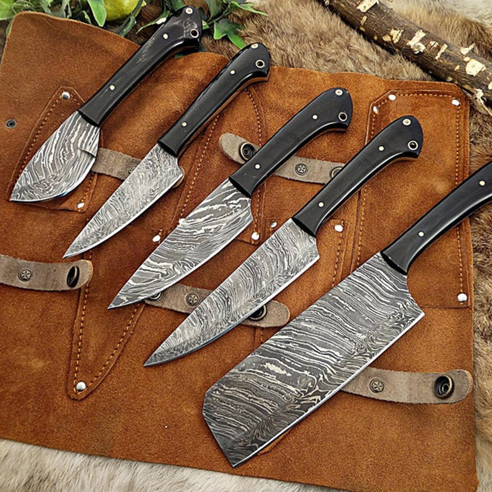 5 piece Damascus steel kitchen knife set with wood handles displayed on a brown leather roll