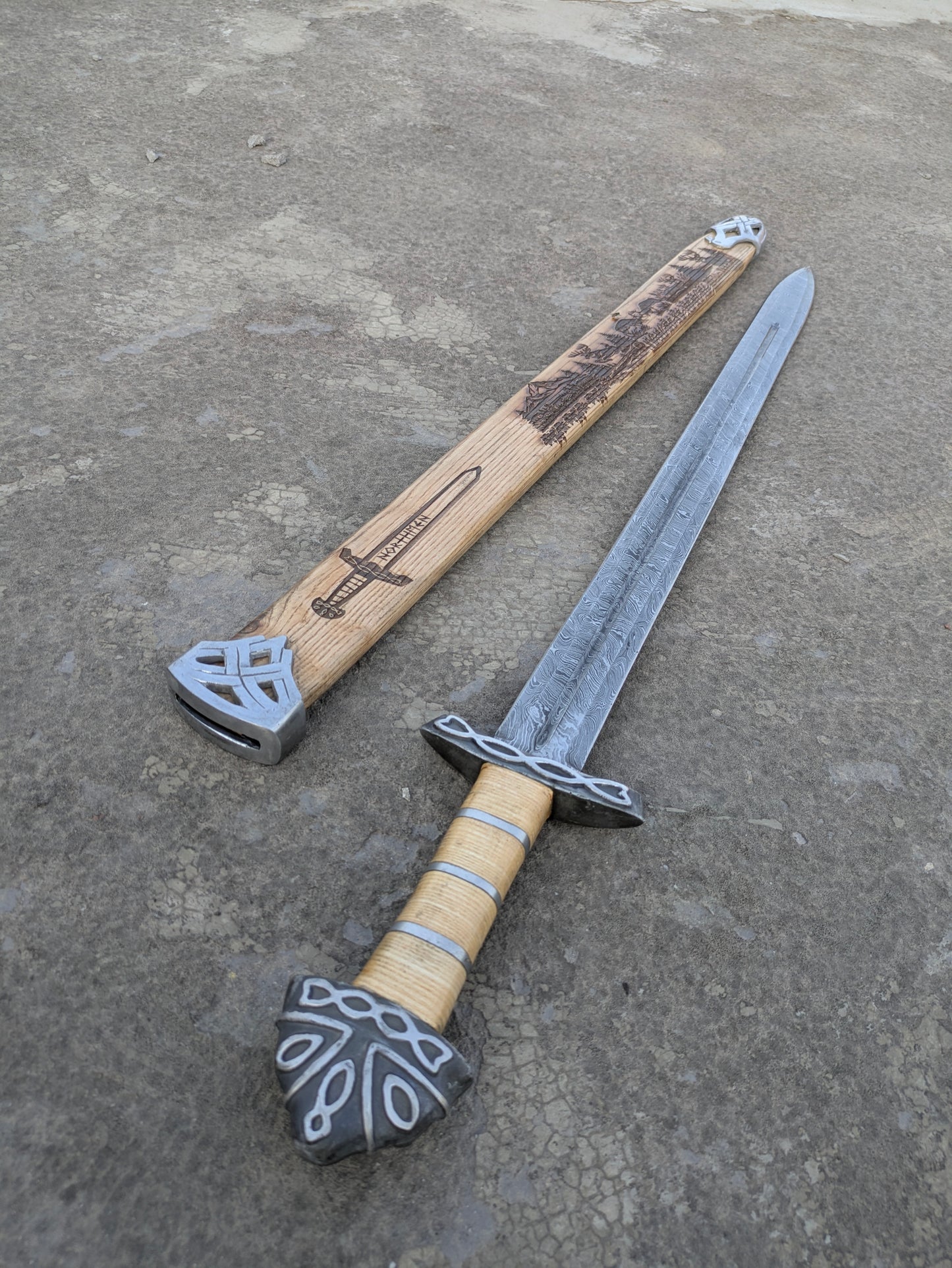 Damascus Steel Northman Viking Sword with wood grip beside Northmen engraved scabbard