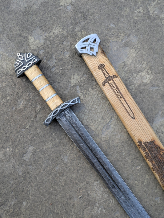 Damascus Steel Northman Viking Sword with wood grip beside engraved wooden scabbard