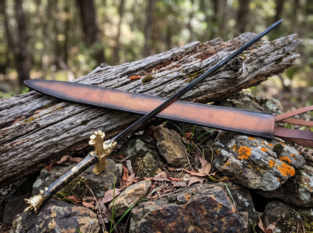 Decorative sword with dark blade, black and gold patterned grip and gold crossguard beside a brown leather sheath