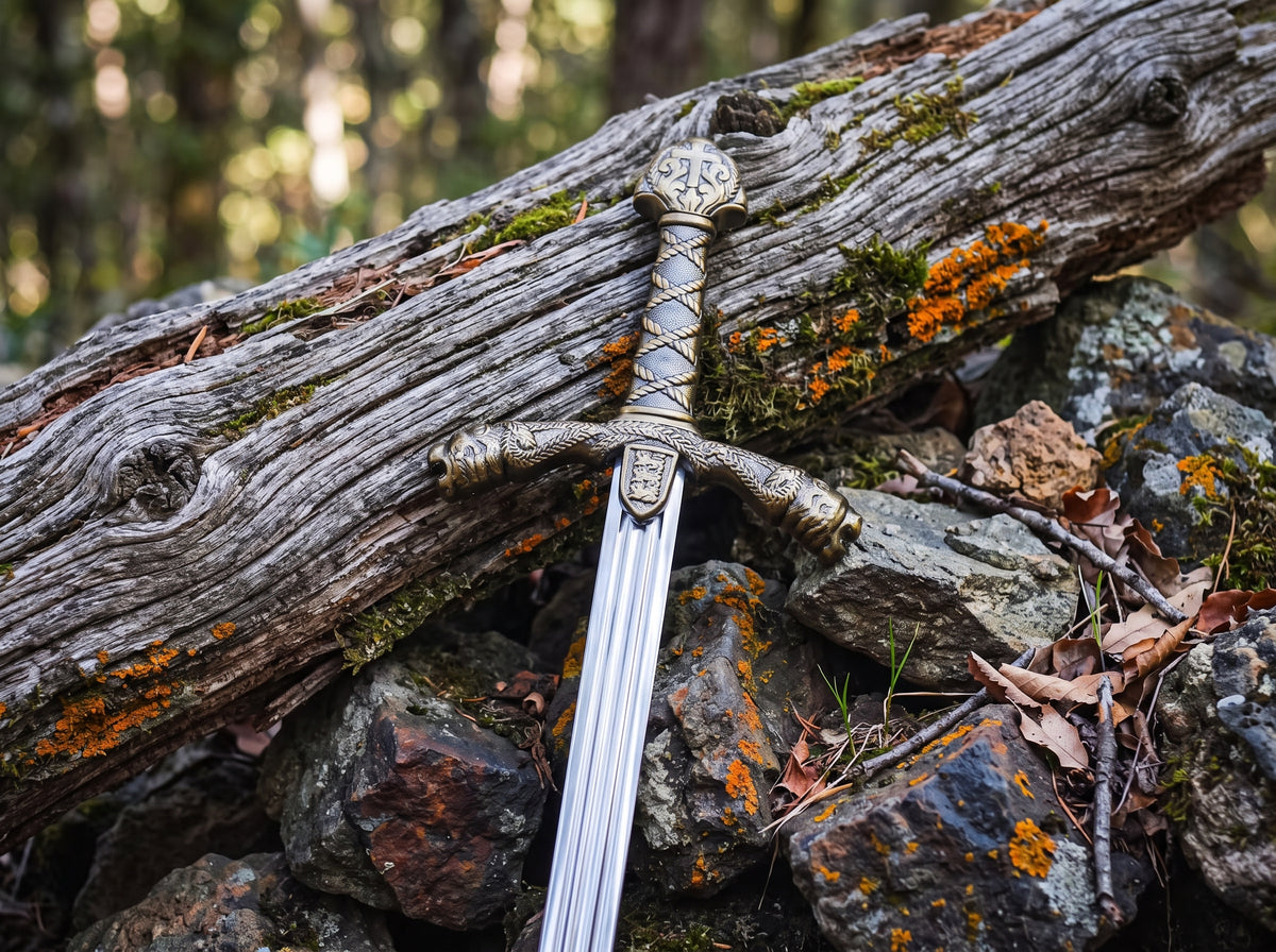 Close up of decorative sword with rope wrapped grip, lion head crossguard and shield emblem on a mossy log