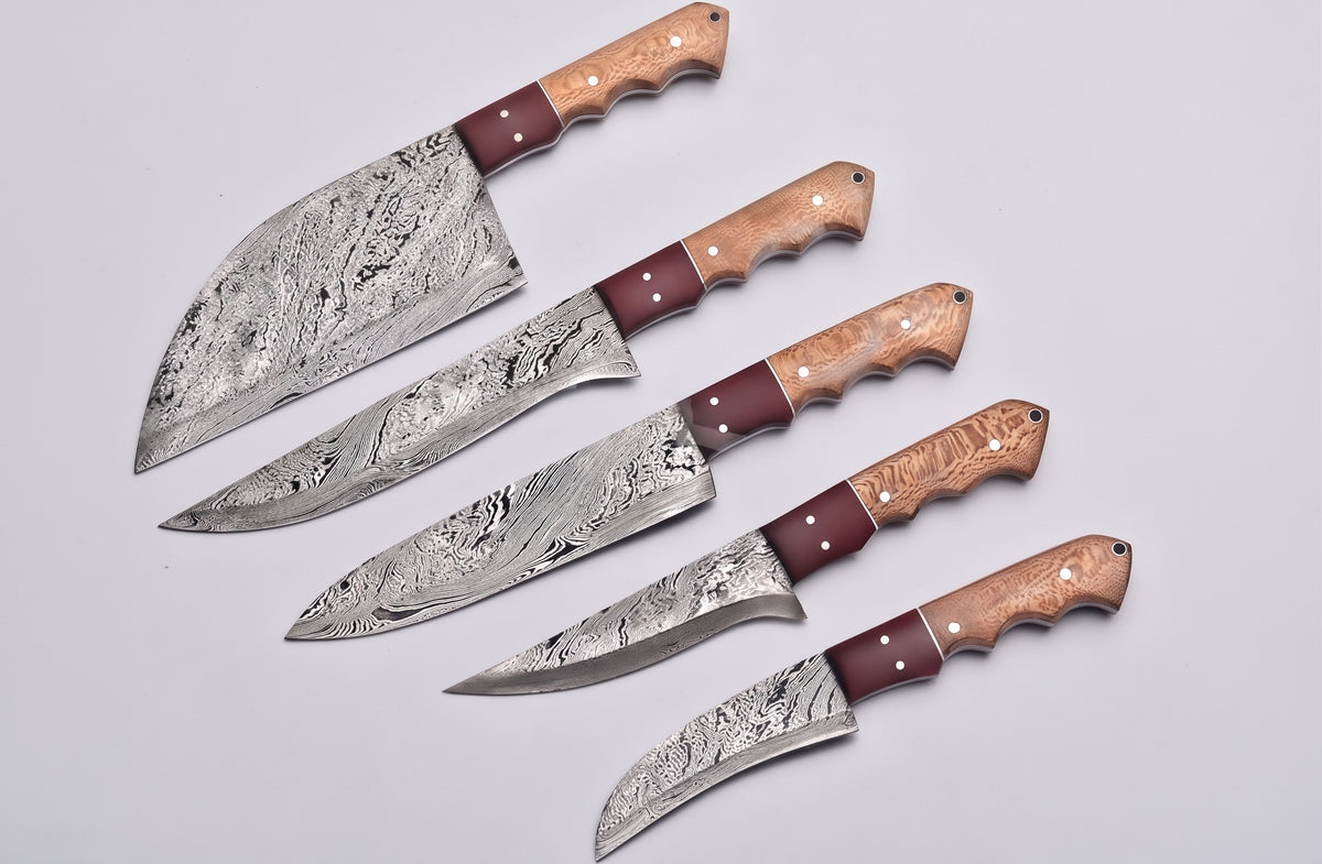 5 piece Damascus knife set fanned closely on white background