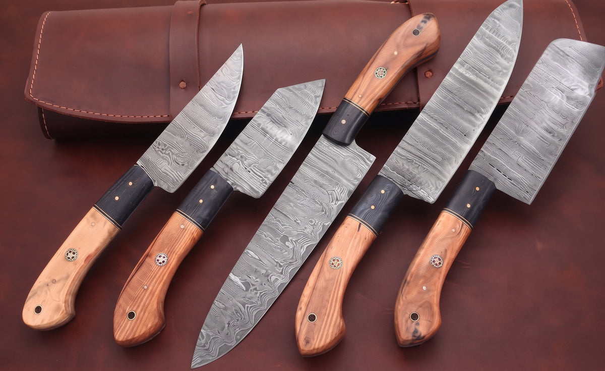 Damascus steel chef knife set with two tone wood handles beside a brown leather roll cass
