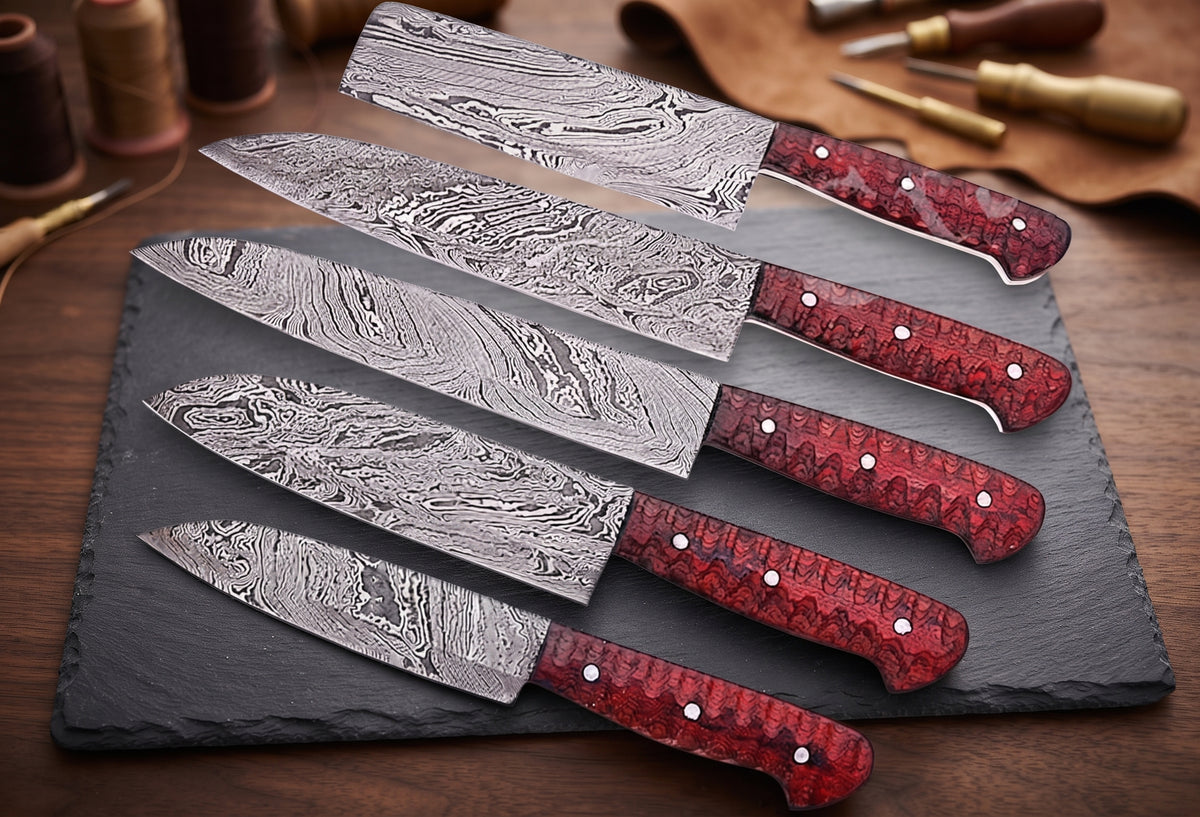 5 Damascus knives with red handles fanned on slate