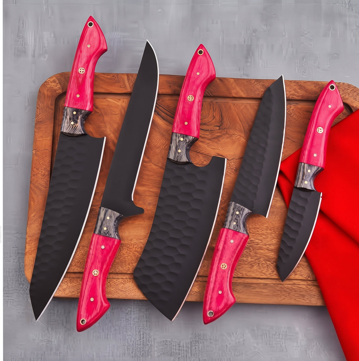 5 piece knife set with pink handles arranged on wood