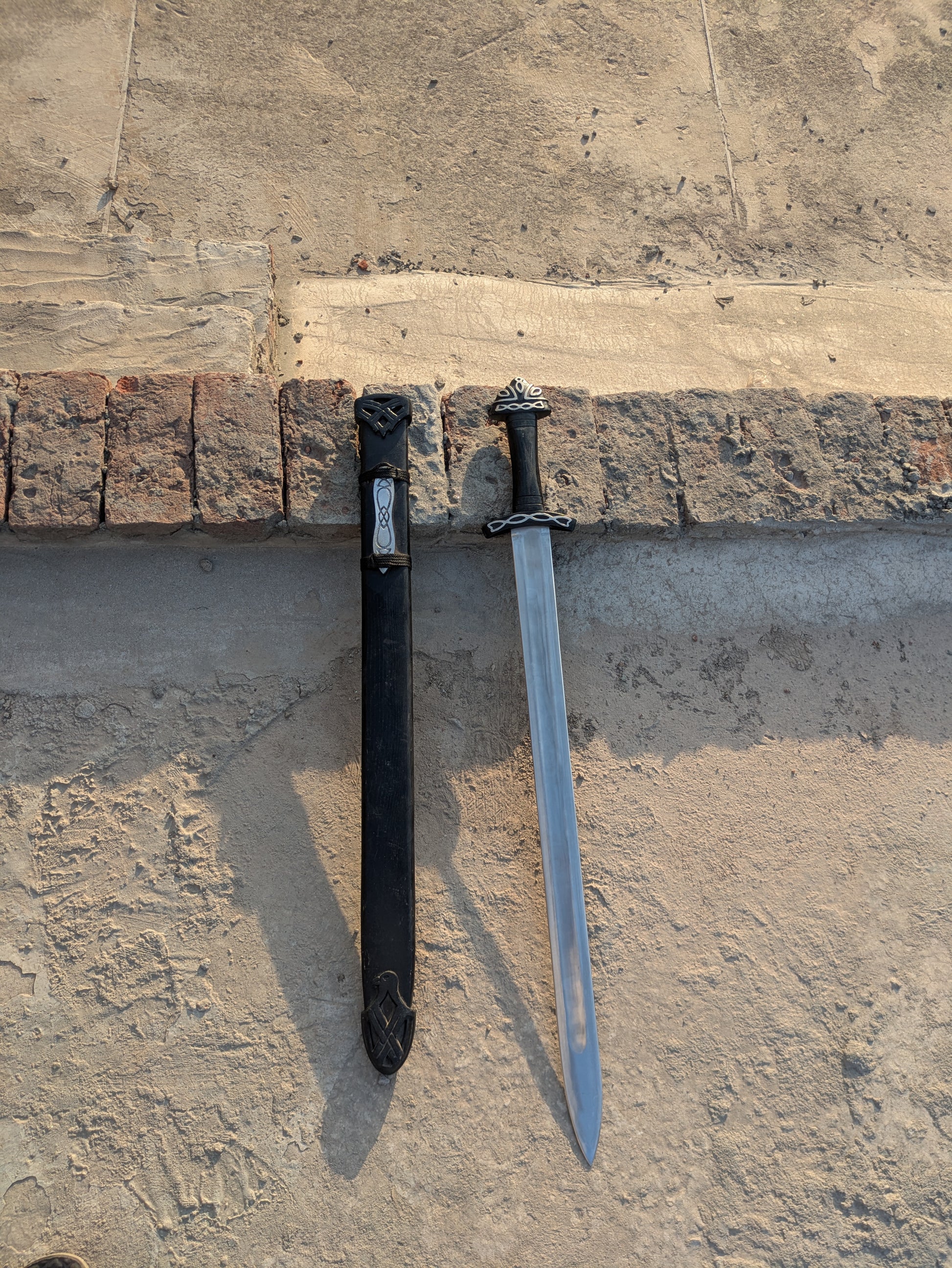 Handmade Fantasy Sword with black hilt and full blade beside matching black scabbard