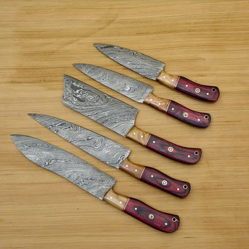 Red pakka wood knife handles with tan bolster fanned on wood table