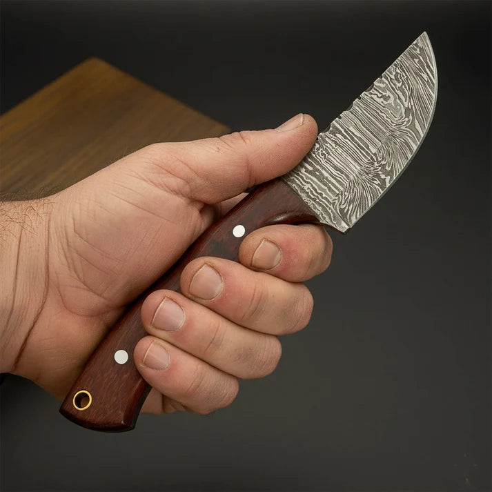 damascus steel skinner knife hold in hand