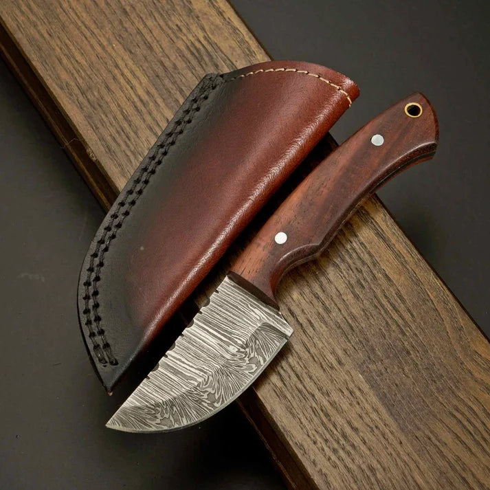 Damascus steel skinner knife with wooden handle and stitched leather sheath