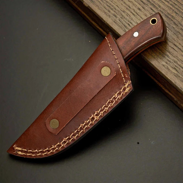 Handmade skinner knife displayed inside leather sheath