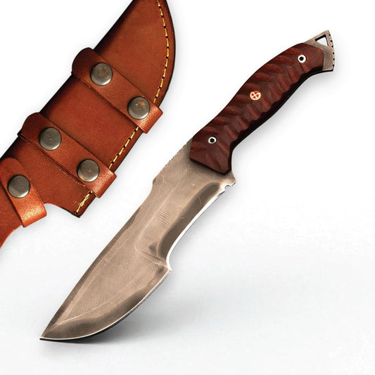 A silver full tang tracker knife with a textured brown handle rests beside its brown leather sheath.