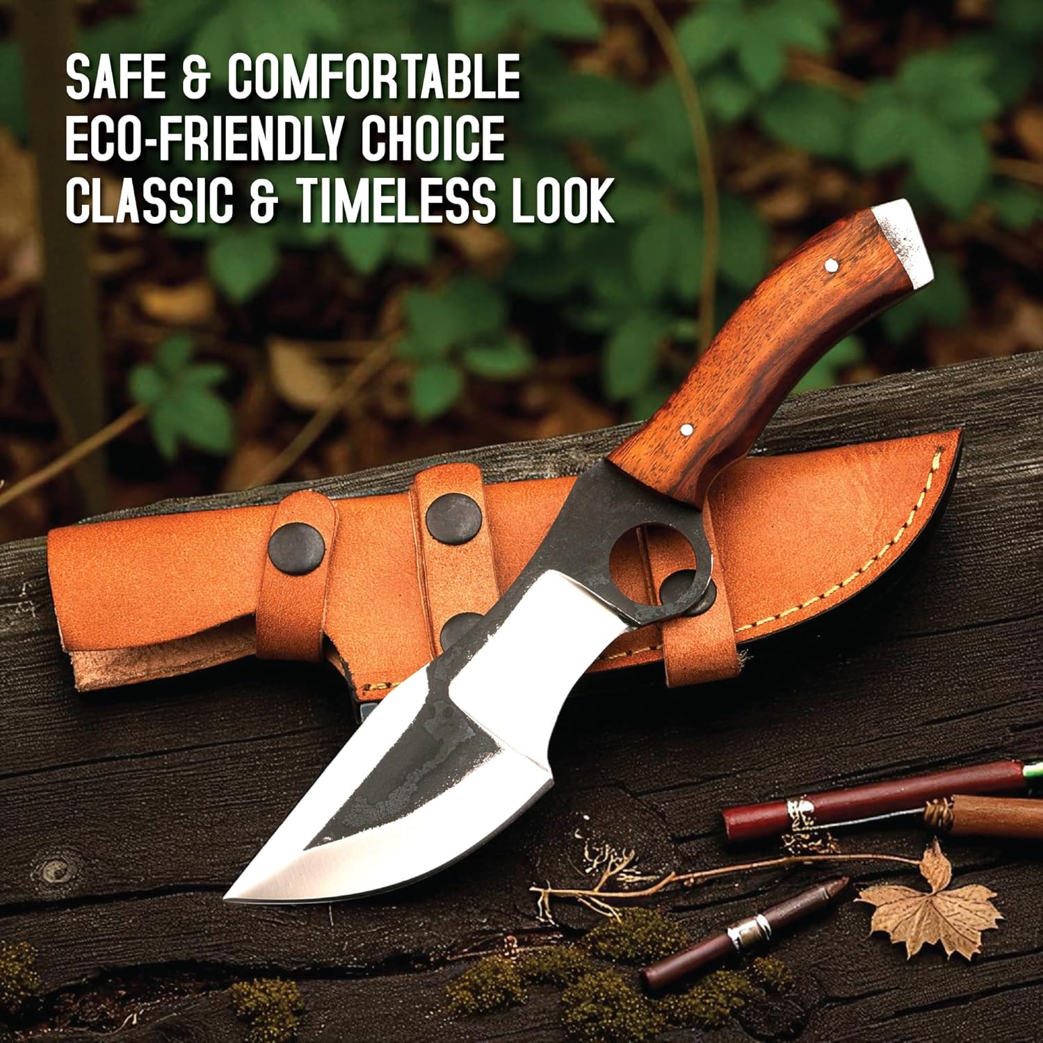 A hunting tracker knife resting on a weathered, dark wooden log alongside a tan leather sheath, set against a blurred background of green foliage. The knife features a polished wooden handle with silver pins and a flat metal pommel. Its distinct blade has a dark, textured upper section with a large circular finger hole, contrasting with the bright, polished silver cutting edges. The leather sheath displays visible yellow stitching and two retaining straps with dark metal snap closures. A few scattered dry l