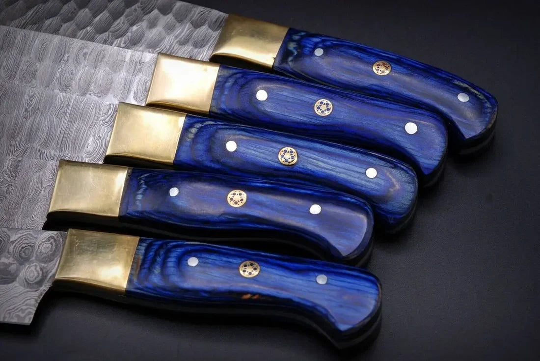 Blue pakkawood knife handles with brass bolsters and a mosaic pin up close