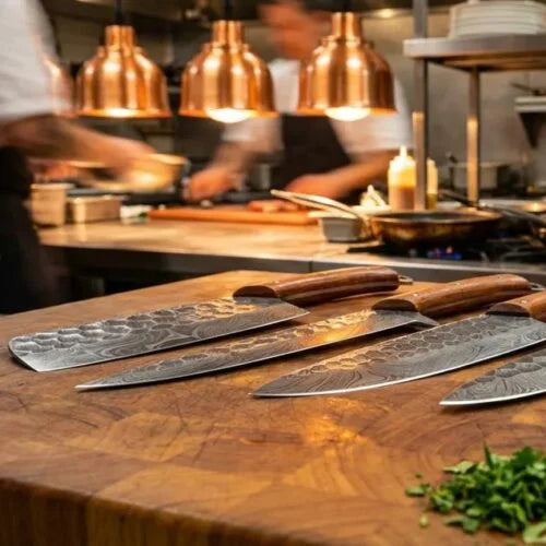 Commercial kitchen view with handcrafted Damascus steel chef knives placed on a wooden counter