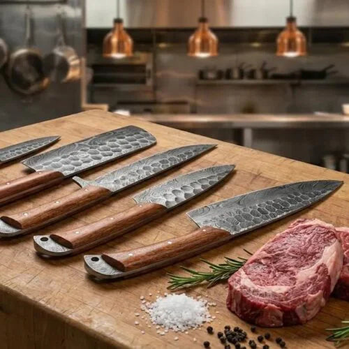 Close up view of hammered Damascus steel kitchen knives displayed on a wooden prep board