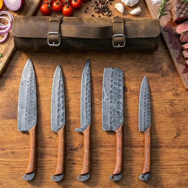 5 piece Damascus steel kitchen knife set laid out alongside a brown leather roll bag on a wooden table