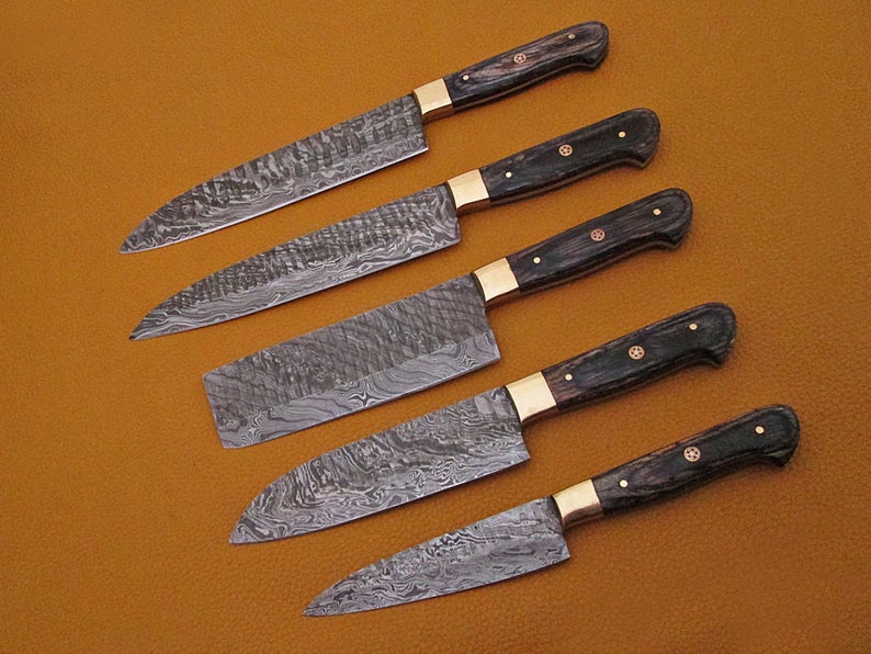Black pakka wood handle knives with brass bolster laid out in a row