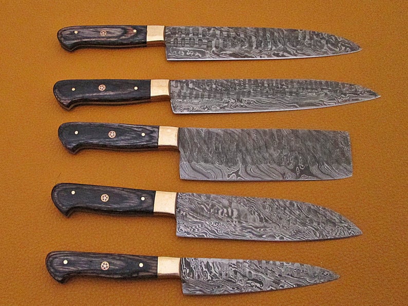 5 piece Damascus steel chef knife set with black pakka wood handles in a row